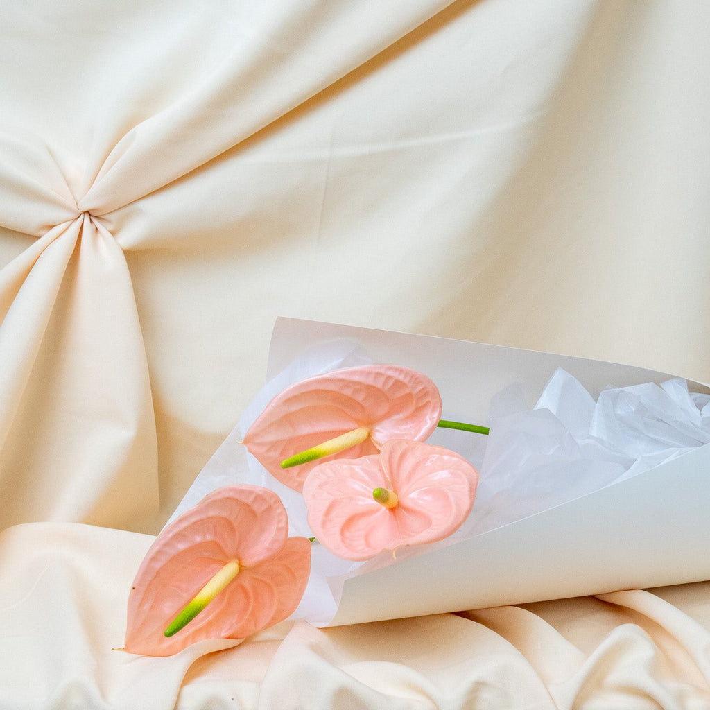 Pink flowers on a white napkin with a beige fabric background