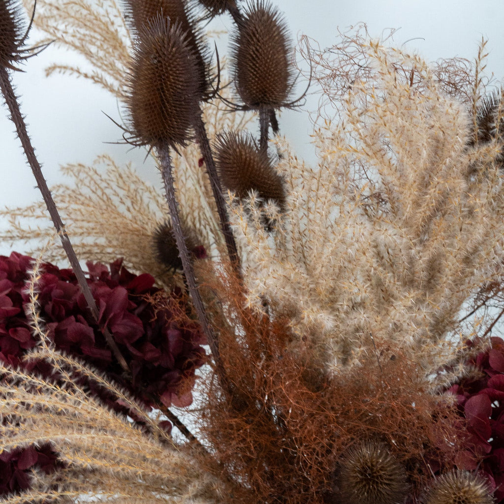 Bouquet of dried flowers with pink and brown tones on a white background