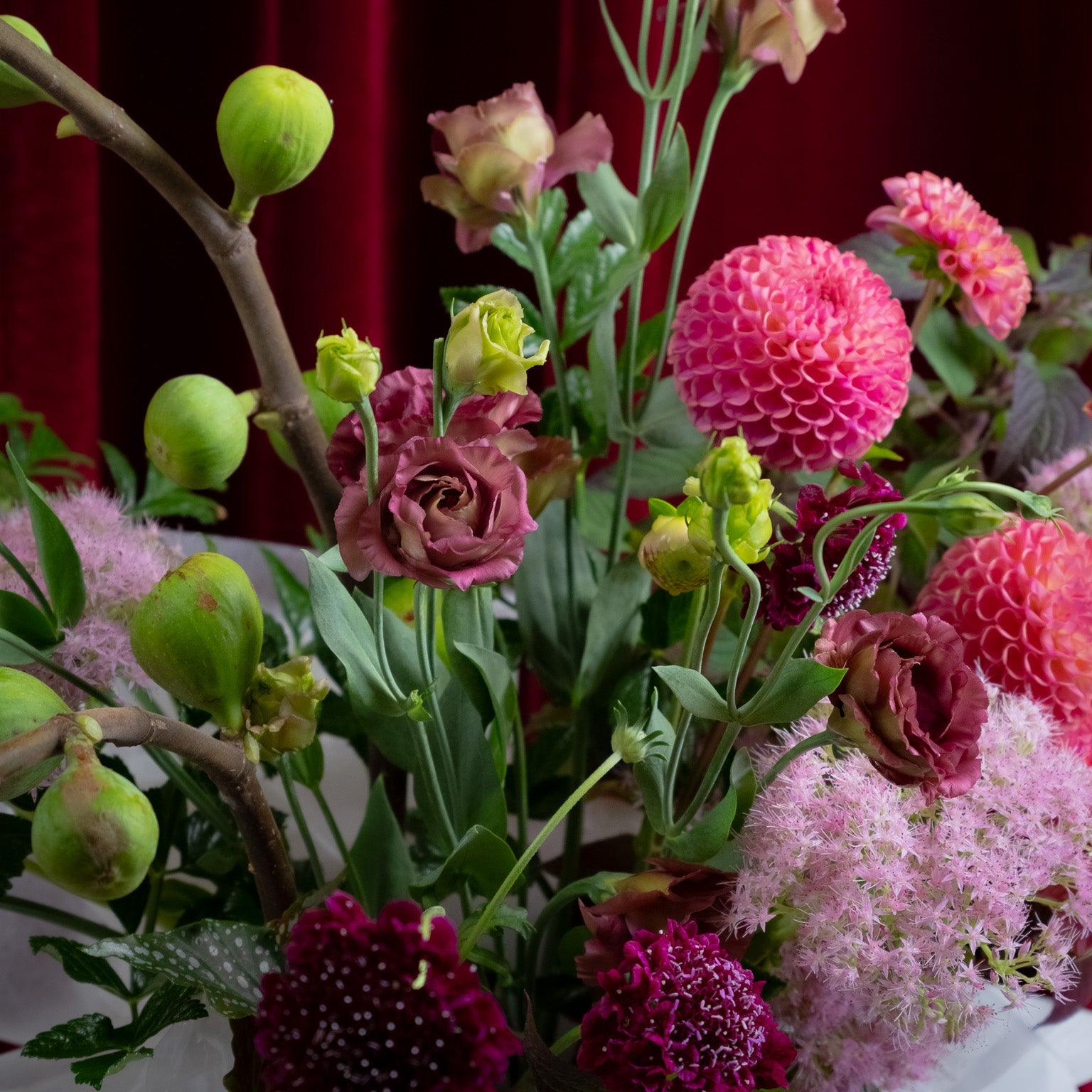 Bouquet of flowers with pink, green, and purple colors against a dark background